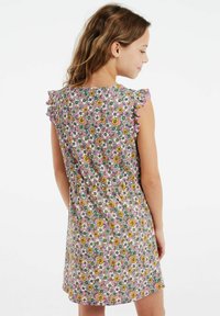 Blumenmuster-Kleid mit pinken, gelben und weißen Blumen auf grünem Hintergrund. Rüschensleeves und taillierte Details.