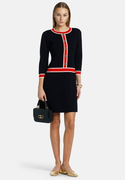 Navy knit dress with red and white accents, featuring a round neckline, button front, three-quarter sleeves, and ribbed waist band.