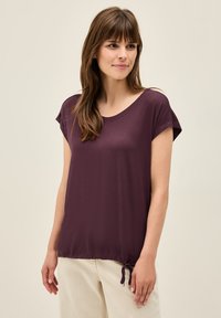 Haut court à manches courtes bordeaux avec un large col et un ourlet à cordon ajustable. Tissu doux avec une texture lisse, coupe décontractée.