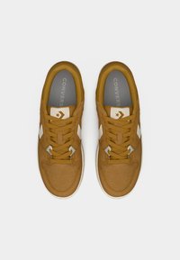 Καφέ σουέντ αθλητικά παπούτσια με λευκές λεπτομέρειες, με σχεδιασμό δέσιμου κορδονιού, στρογγυλεμένη μύτη, επενδυμένο γιακά και λογότυπο στη γλώσσα του παπουτσιού.