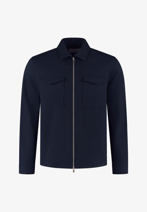 Marineblå langærmet jakke med krave, lynlås foran og to brystlommer med klapper, vist på en hvid baggrund.