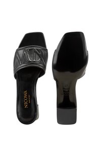 Zwarte leren slidesandalen met een brede band met geïmplanteerde letters, een vierkante neus en een mid-height blokhak. Textuur in de binnenzool.