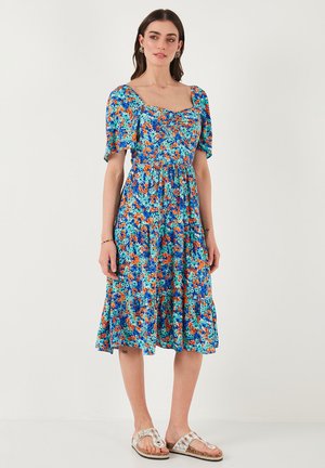 Floral midi dress in blue, featuring a square neckline, short puff sleeves, and a fitted waist, with vibrant orange and green flower prints.