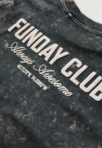 Šedá mikina s nápisy "FUNDAY CLUB" a "Always Awesome" bílým písmem. Materiál má opotřebovaný vzhled s jemnými variacemi.