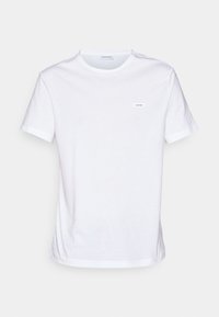 Biała bawełniana koszulka z krótkimi rękawami, okrągłym dekoltem i małym prostokątnym logo Calvin Klein na piersi. Gładka faktura.