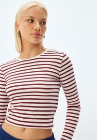 Langemouw, cropped top met kastanjebruine en crème horizontale strepen, met een ronde halslijn en zachte, licht rekbare stof.