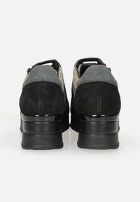 Scarpe in suede nere e grigie con tacco arrotondato, caratterizzate da un accento nero lucido sulla base e un design elegante. La vista posteriore mostra la chiusura con zip.