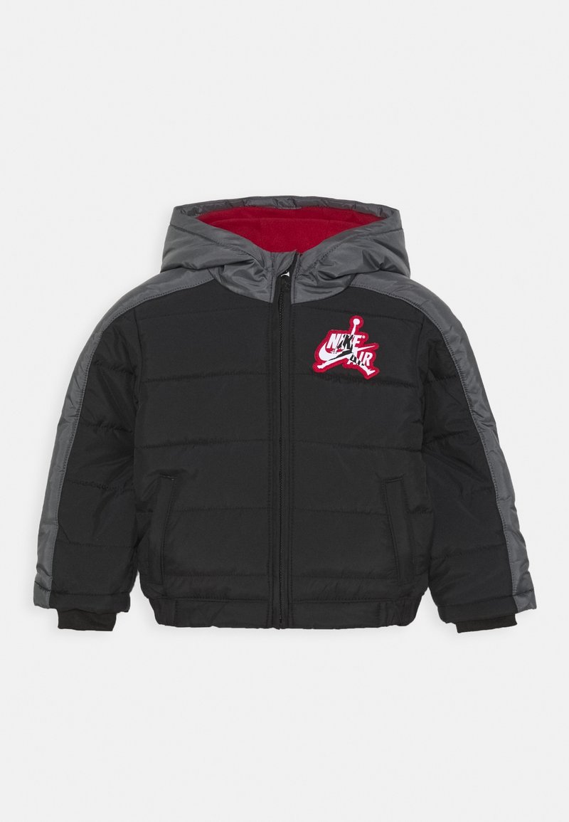 Czarna i szara pikowana kurtka z kapturem Nike Air z czerwonym wyściółką w środku i przednim zamkiem błyskawicznym, z logo Nike Air na piersi.