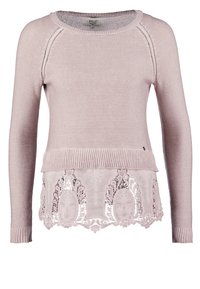 Maglione rosa chiaro a maniche lunghe, parte superiore lavorata a maglia e orlo con pizzo che presenta intricate fantasie floreali. Collo e polsini a coste.