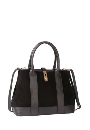 Sac à main en suède et cuir noir avec double poignée, bandoulière réglable et fermeture à rabat dorée sur fond blanc.