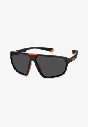 Occhiali da sole rettangolari neri opachi con lenti scure e accenti arancioni brillanti sulla montatura e sulle punte delle tempie, marchiati Polaroid.