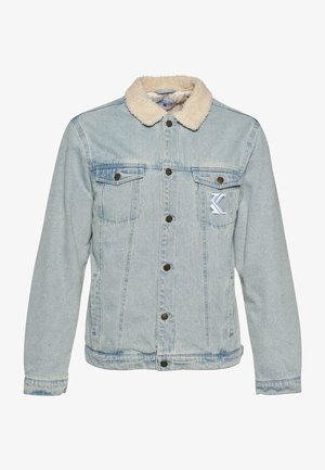 Helehall denim-jakk, millel on pehme beež krae, ees nööbid, rinnataskud ja vasakul küljel tikandiga logo detail.