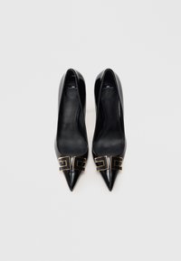 Μαύρες δερμάτινες ψηλοτάκουνες γόβες με μυτερά δάχτυλα, διακοσμημένες με χρυσές γεωμετρικές λεπτομέρειες στο μπροστινό μέρος. Ομαλή υφή και κομψός σχεδιασμός.