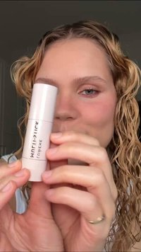 Rundes, weißes Stäbchen mit schwarzem Text "glow", der prominent angezeigt wird. Glatte Oberflächenstruktur, die das minimalistische Design unterstreicht.