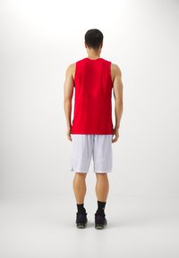 Punane käisteta spordijersey, valged võrgusilma lühikesed püksid, mustad sokid ja lillakate aktsentidega jalanõud. Lühikeste pükste nähtav õmblus ja külgavad slitsid.