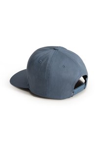 Blå justerbar snapback-keps med ventilationshål, platt skärm och liten varumärkesetag nära den justerbara remmen på en vit bakgrund.
