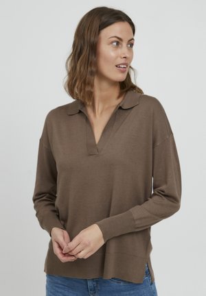 Pull brun à manches longues en tissu doux, doté d'un col polo, d'un léger décolleté en V et de fentes latérales à l'ourlet. Porté avec un jean.