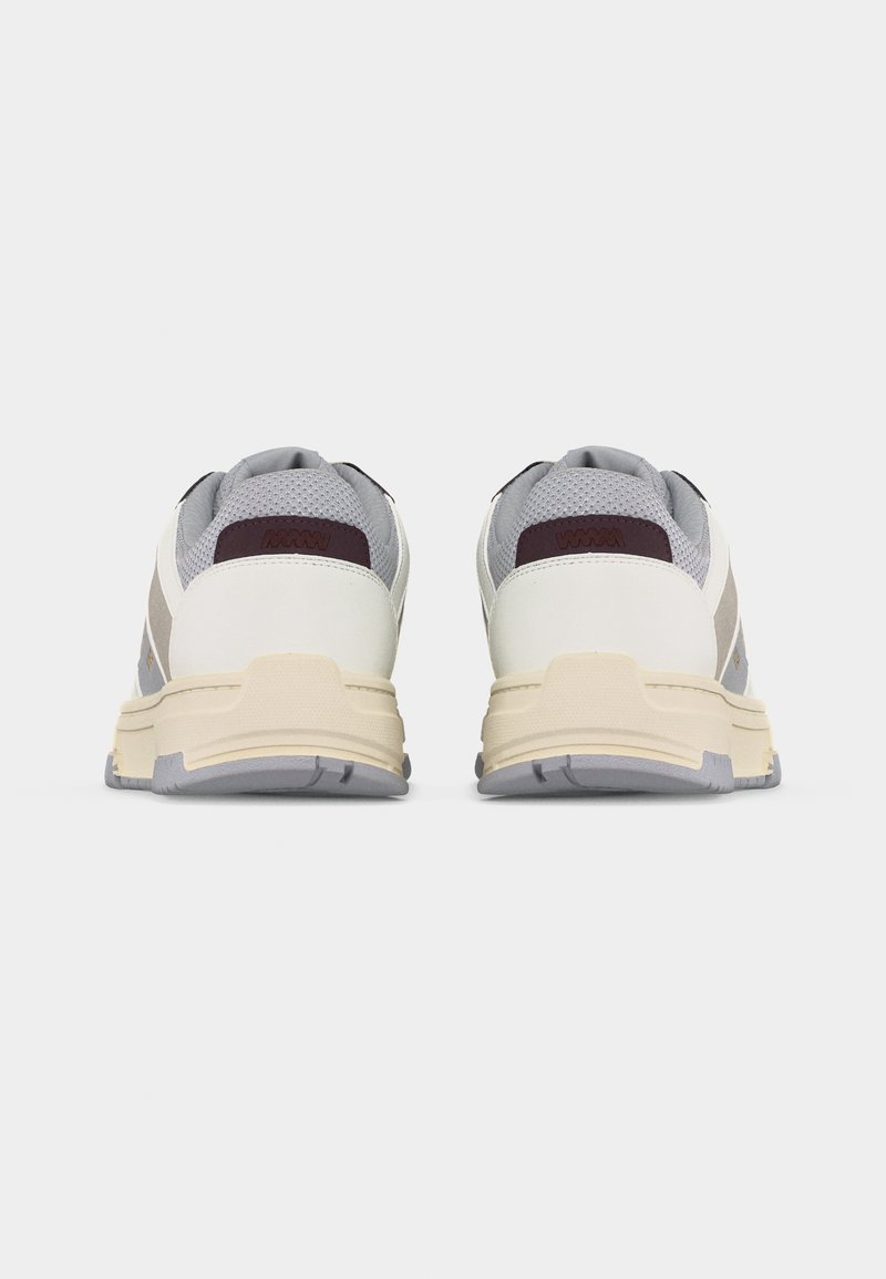 Paire de chaussures de sport blanches et grises avec des semelles beiges, vues de dos sur un fond blanc uni.