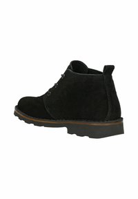 Stivaletti neri in suede a caviglia con punta arrotondata, allacciatura con tre occhielli e suola in gomma testurizzata con un accento marrone sul bordo.