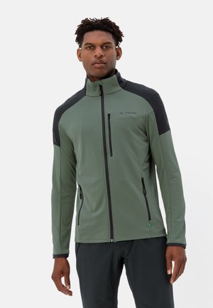 Groene softshell jas met zwarte schouderaccenten, volledige rits, hoge kraag en ritszakken aan de zijkanten. Gestructureerde stof en aangesloten ontwerp.