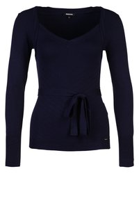 Pull tricoté bleu marine à manches longues, col en V, avec une ceinture nouée à la taille. Caractérisé par une texture côtelée diagonale. Détail logo doré près de l'ourlet.