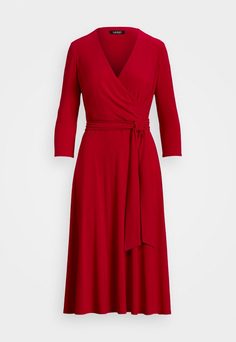 Röd omslagsklänning i mjukt tyg, med V-ringning, trekvartsärmar, bälte vid midjan och en utställd kjol.