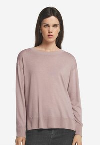 Ljusrosa långärmad tröja med rund halsringning, ribbade ärmslut och nederkant. Mjuk textur med en avslappnad passform och sänkta axlar.