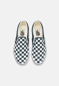 Čierno-biele slip-on tenisky s karovaným vzorom, plátenným zvrškom, gumovou podrážkou a polstrovanou stielkou. Logo štítok na boku.