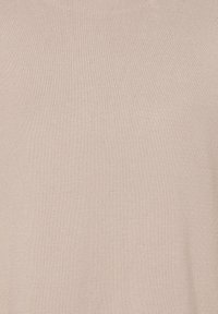 Ljust beige stickad tyg med en jämn textur och ett konsekvent mönster. Materialet verkar mjukt och flexibelt.