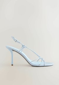 Sandale à talon haut bleu clair avec fines lanières, bout ouvert et boucle de cheville réglable sur fond neutre.