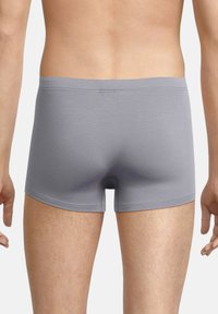 Boxer shorts grigi in cotone con una texture liscia, cintura elastica e vestibilità aderente, mostrati da dietro su uno sfondo neutro.