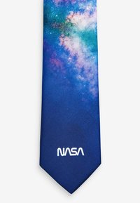 Blue tie featuring a galaxy print with stars and nebulae. "NASA" logo in white at the bottom. Smooth texture, modern design.