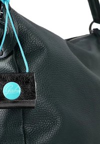 Borsa in pelle nera con texture, con un'etichetta turchese su cui è scritto "Gabs" in corsivo. L'etichetta è attaccata con un cordino blu. La borsa ha un aspetto morbido.