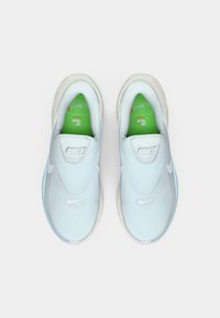 Ανοιχτό μπλε αθλητικά παπούτσια τύπου slip-on με επάνω μέρος από δίχτυ, λευκό λογότυπο Nike και πράσινο πάτο. Λείο καουτσούκ σόλα με στρογγυλεμένο σχέδιο στα δάχτυλα.