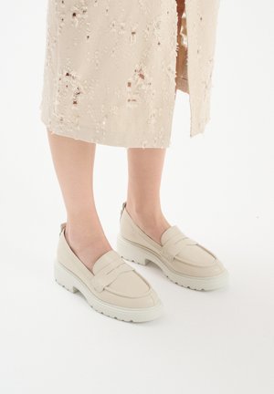 Mocassini in pelle beige con finitura texturizzata, dettagli elasticizzati e una spessa suola in gomma bianca, con cuciture di accento sottili.