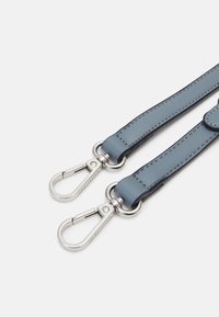 Ljusblått läderarmband med två silverfärgade metallklipp. Har en slät yta och kontrasterande sömmar längs kanterna.