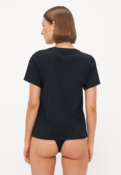 Black cotton t-shirt with short sleeves, round neck, and a relaxed fit, shown from the back, paired with a black thong.