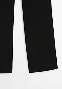 Pantalon noir taille large en tissu lisse, avec une coupe droite, des lignes épurées, sans motifs ni éléments visibles.