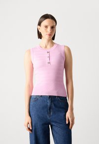Lys rosa ribbet ermeløs topp med rund hals, med tre dekorative knapper foran og en tettsittende silhuett.