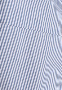 Lightweight cotton fabric featuring narrow, vertical blue and white stripes. Material has a smooth texture with subtle sheen.