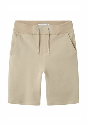 Shorts en coton beige avec une taille élastique, fermeture à cordon, et deux poches latérales. Texture lisse avec des détails de coutures à l'ourlet.