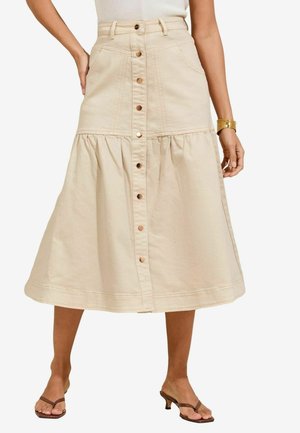 Beige denim rok met een gelaagd ontwerp, voorzien van een voorste knoopsluiting en zakken. De zoom is rond en er zijn zichtbare stikdetails.