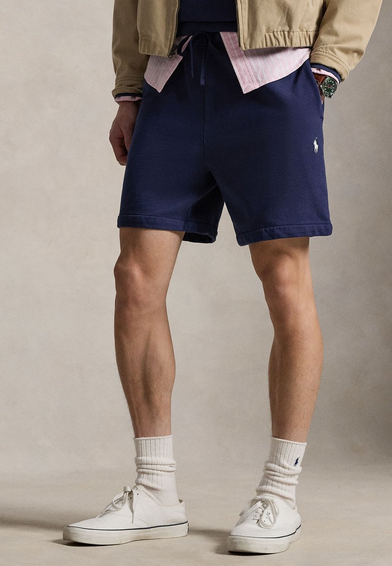 Tamsiai mėlyni medvilniniai šortai su tiesia linija ir susuktomis apačiomis, su elastinga juosmens juosta ir mažu logotipu kairiajame šlaunyje.