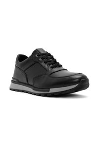 Sneaker in pelle nera con design a lacci, collo imbottito e suola in gomma texturizzata, angolato per mostrare i dettagli laterali e frontali.