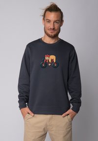 Sweatshirt gris foncé avec un graphique coloré d'un personnage faisant du vélo. Le matériau semble doux, avec une coupe décontractée et un col rond.
