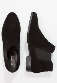 Stivali alla caviglia in suede nero con pannelli laterali elastici, punta rotonda e tacco in gomma basso. Texture liscia con design minimalista.