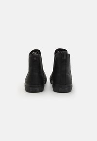 Black high-top shoes feature a smooth leather material, rounded toe, textured accents, and rear pull tabs for easy wearing.