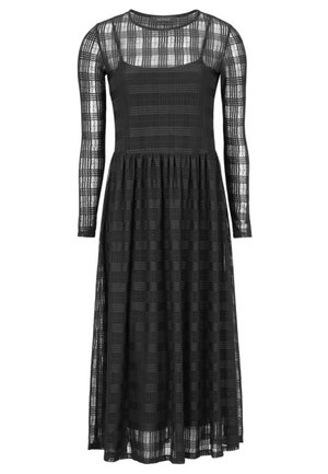 Robe midi noire avec manches longues transparentes et superposition avec un motif à carreaux subtil et un jupon noir uni en dessous.