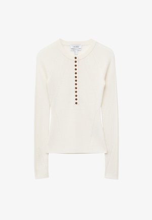 Ivory long-sleeve knit top featuring a round neckline, a button front with dark brown buttons, and side panels for a fitted silhouette.