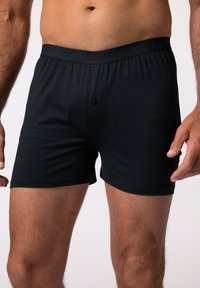 Boxer in cotone nero con elastico morbido, dotati di un bottone singolo davanti e una texture liscia.